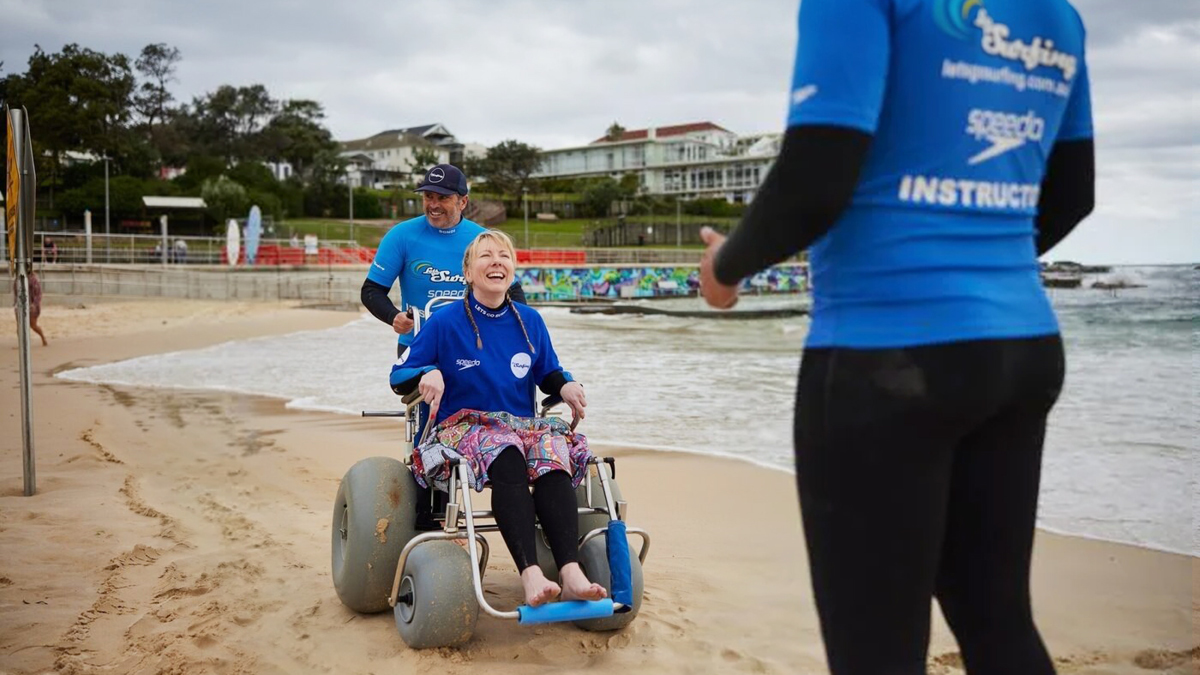 호주 해변에서 수중휠체어를 타고 있는 여행객