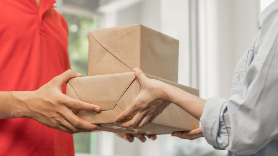 택배박스를 주고 받는 두 사람의 손