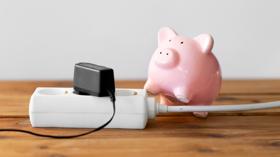 멀티탭 옆에 돼지저금통이 놓여 있어요.