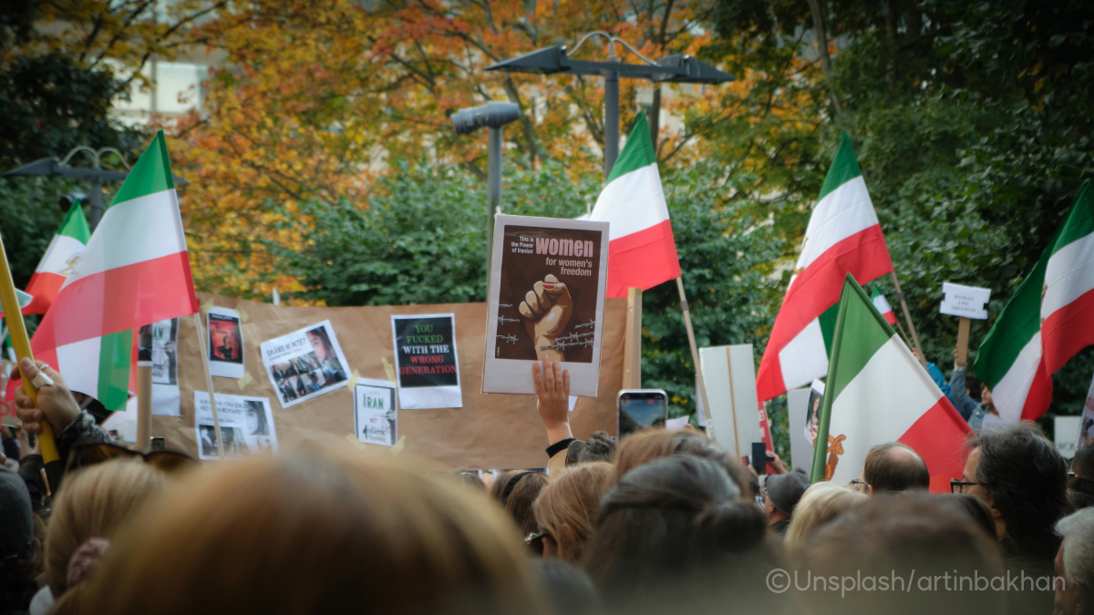사람들이 이란 국기와 "women's freedom"이라고 적힌 피켓을 들고 시위하는 모습이에요.