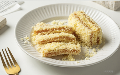 흰 접시 위에 호박 인절미가 놓여 있는 모습