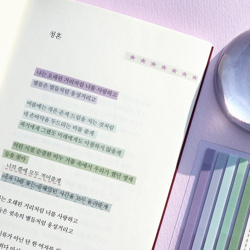 연보라색 바탕에 펼쳐진 책과 인덱스가 놓인 모습이에요. 이미지 왼쪽에는 책 페이지 위 글씨에 색깔별로 인덱스가 붙어 있어요.