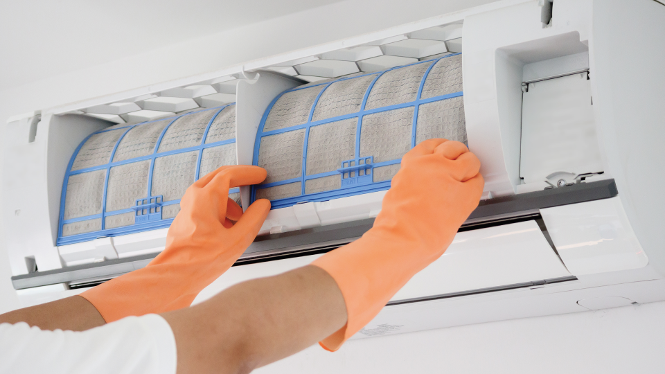 청소를 위해 에어컨 필터를 분리하는 모습이에요.