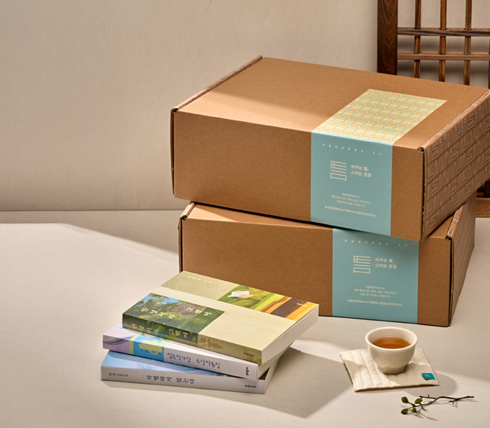 테이블 위에 책 3권과 박스 2개가 쌓여 있는 모습이에요.