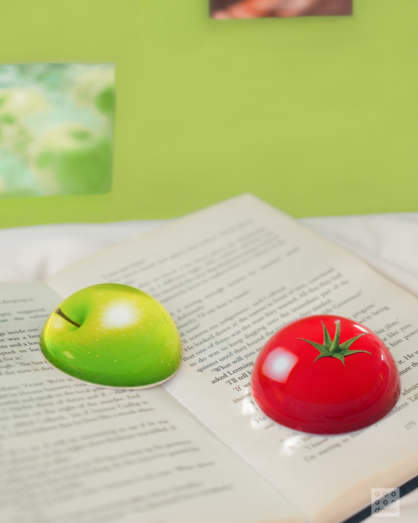 연두색 배경, 펼쳐진 책 위 양쪽에 연두색 사과 모양 문진과 빨간색 사과 모양 문진이 올려져 있어요.