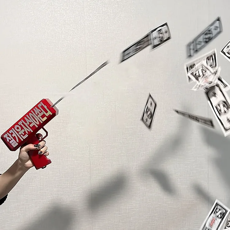 '잘키운자식이쏜다' 텍스트가 붙어 있는 빨간색 머니건에서 돈이 발사되는 모습.