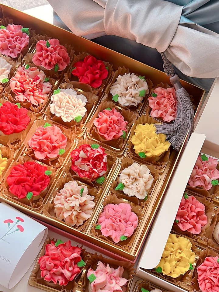 상자에 빨간색, 분홍색 등 다양한 색깔의 카네이션 모양 앙금쿠키가 담겨 있는 모습.