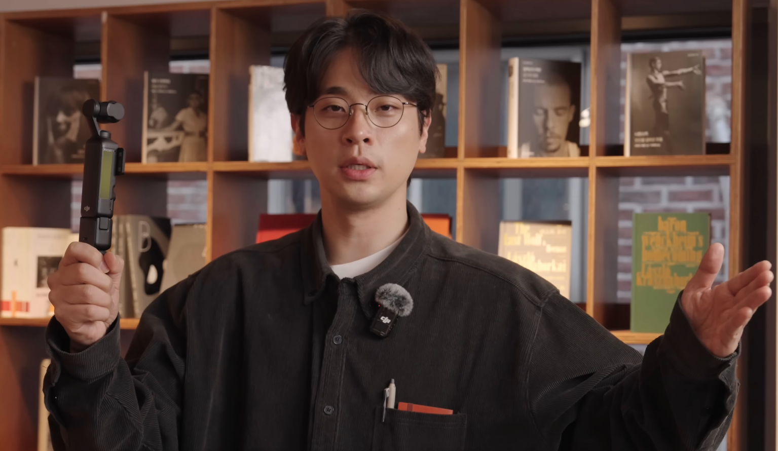 박정민 배우가 책장을 배경으로 서 있는 모습.